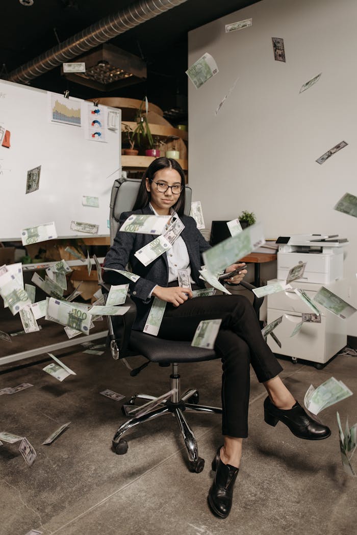 Businesswoman in modern office with falling cash, symbolizing financial success.
